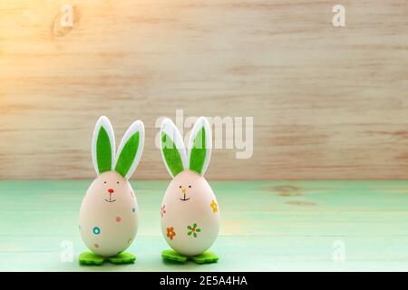 Easter rabbits toys on vintage wood background. Funny Easter decoration. Easter mood with bunnies toys. Copy space. Stock Photo