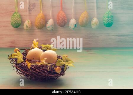 Easter rabbits toys, row of hanging eggs on vintage wood background. Funny Easter decoration with copy space. Easter mood. Stock Photo