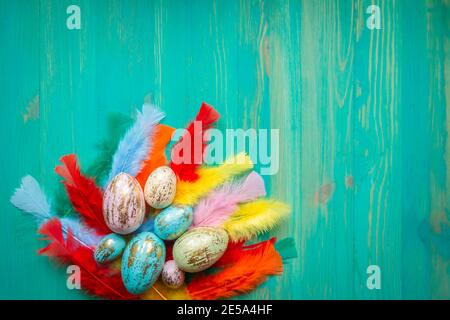 Easter eggs and feathers on vintage wooden turquoise painted table. Modern Easter decoration. Vintage style Easter background with copy space. Top vie Stock Photo