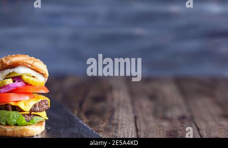 A big, fat, juicy double cheeseburger made with two 100% beef patties, slices of melted cheese, onions, pickles, lettuce, tomatoes, and mayo on a fres Stock Photo