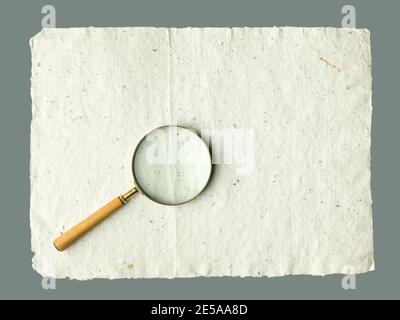 Recycled cream, grey vintage horizontal note paper texture. Vintage magnifier on top. Stock Photo