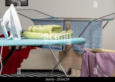 Housework concept. Ironing towels on ironing board Stock Photo