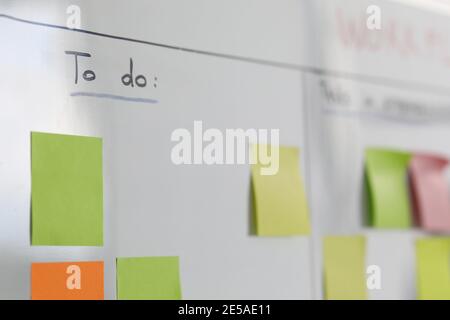 Many colorful stickers hanging on white board closeup Stock Photo