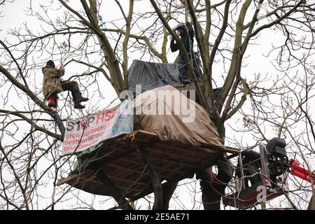 A HS2 Rebellion protester on a zip line between two trees in an encampment in Euston Square Gardens in central London, where the protesters have built a 100ft tunnel network, which they are ready to occupy, after claiming the garden is at risk from the HS2 line development. The spire of St Pancras New Church is in the background. Picture date: Wednesday January 27, 2021. Stock Photo