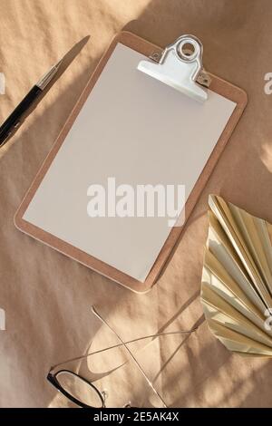 Minimal stationery still life. Dry palm leafs on craft paper. Stock Photo