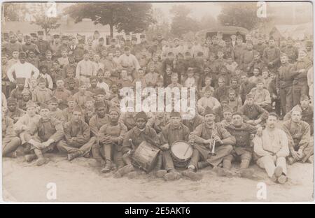 Large group of French and African soldiers together in camp during the First World War. At the front of the group are three men (two white, one black) with musical instruments - a trumpet, drums and a cymbal Stock Photo
