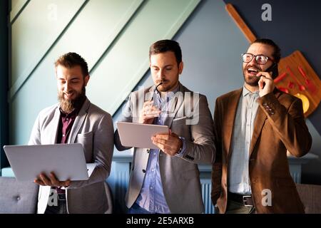 Group of confident happy business people holding digital devices Stock Photo