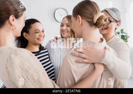 happy multicultural female team hugging during seminar Stock Photo