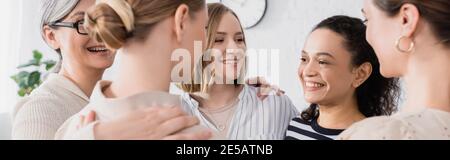 happy multicultural team hugging during seminar, banner Stock Photo