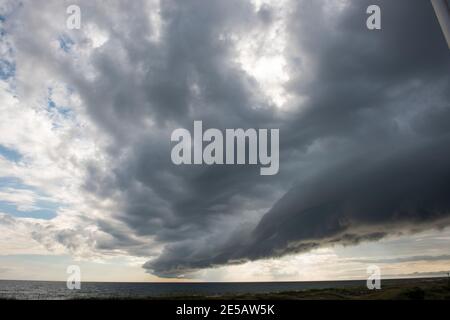 A shelf clouds appears on the leading edge of a storm in Atlantic Beach, North Carolina. Shelf clouds are a type of arcus cloud, which is a low, horiz Stock Photo