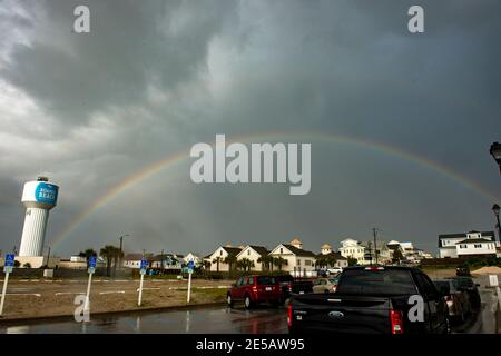 A rainbow glows in the sunshine after a storm passed through  Atlantic Beach, North Carolina. A faint double rainbow can be seen. Stock Photo