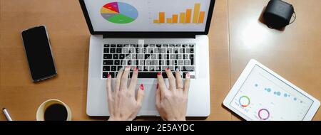Top view of a woman typing on a laptop on working desk Stock Photo