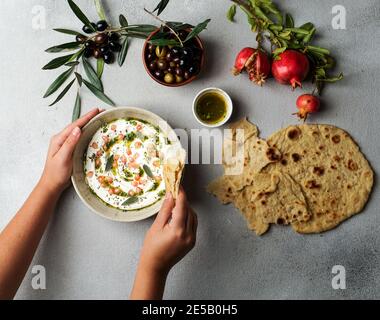 iranian or arabian dish, yogurt labneh goats milk dip with taftan bread and pomegranate Stock Photo