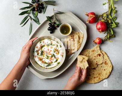 iranian or arabian dish, yogurt labneh goats milk dip with taftan bread and pomegranate Stock Photo