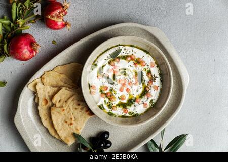 iranian or arabian dish, yogurt labneh goats milk dip with taftan bread and pomegranate Stock Photo