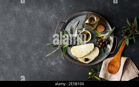 fresh black and green olives and olive oil on concret background. Top view with copy space for text Stock Photo