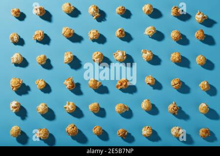 A pattern of popcorn patterns on a blue background. Full screen as a conceptual background. Hard light with shadow Stock Photo