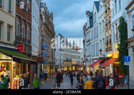 BRUSSELS, BELGIUM - OCTOBER 06, 2019: Crowd of people walking by Old Town shopping street of Brussels at twilight Stock Photo