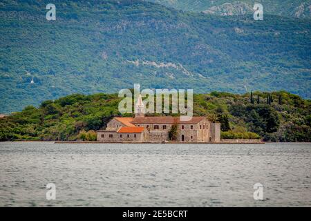 Beautiful shot of the bay of Kotor in Montenegro. Historical building on island in front of mountain Stock Photo