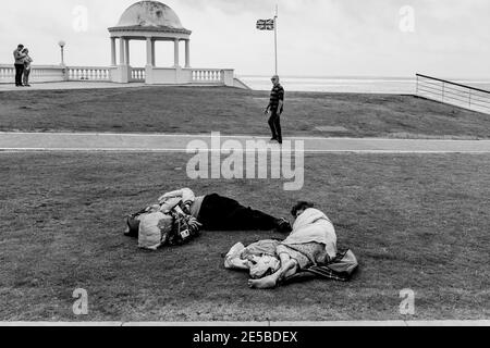 Two People Sleeping/Resting On The Lawns At Bexhill On Sea, East Sussex, UK. Stock Photo