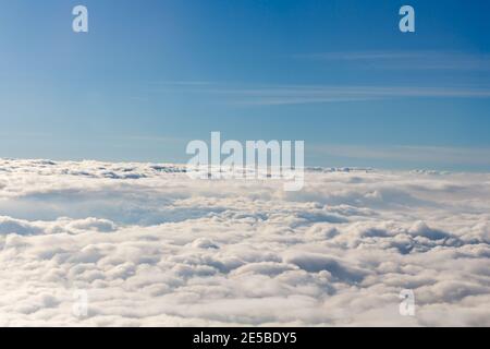 A view of the horizon formed above fluffy white clouds in the sky. Stock Photo