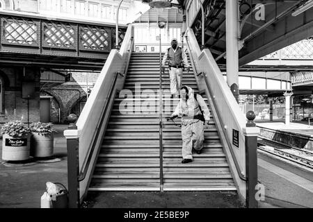 Workers In Protective Suits Clean The Holding Rails At Lewes Railway Station During The Covid 19 Pandemic, Lewes, East Sussex, UK. Stock Photo