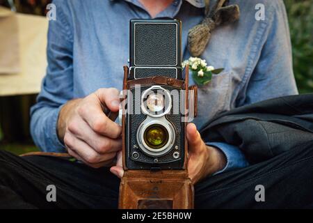Close up portrait of man holding vintage camera. Retro Shooting. Stock Photo
