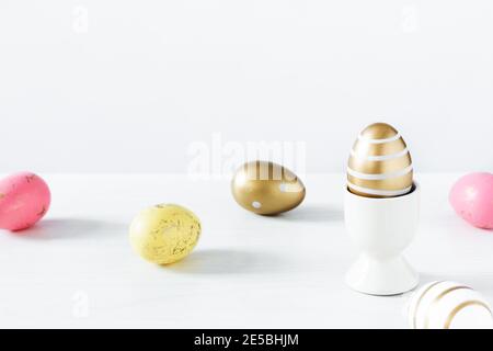 Colorful Easter eggs on white wooden table over white background. Easter holiday greeting card. Stock Photo