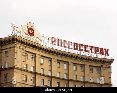 The emblem of the company and the inscription in Russian Rosgosstrakh, an abbreviation of the Russian State Insurance Company, on the roof of a reside Stock Photo