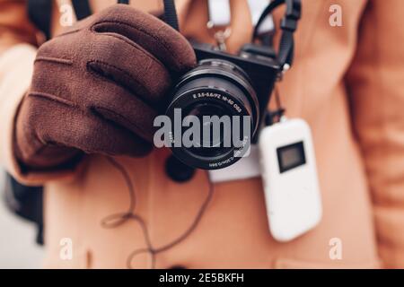 Tourist using wireless digital audio tour guide equipment with earphones. Man traveler goes sightseeing with camera. Modern devices for excursions Stock Photo