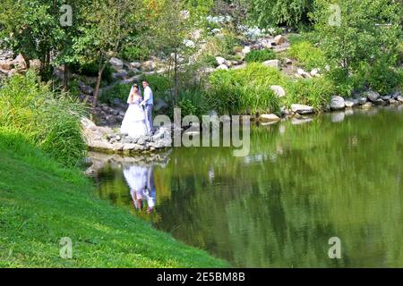 KYIV, UKRAINE - AUGUST 12: Bride and groom near the lake on August 12, 2012 in Kyiv, Ukraine Stock Photo