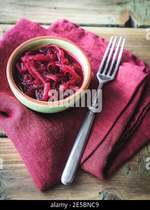 Bowl of sliced beetroot on wooden table. Red linen on background. Copy space.  Stock Photo