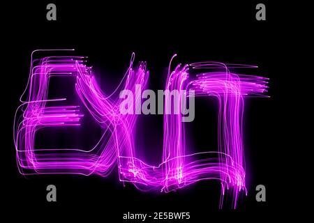 'Exit' word written in pink light on black background. Long exposure neon light photograph. Stock Photo
