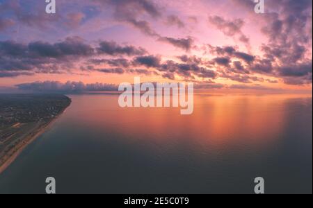Seascape, seashore during sunrise. Landscape with calm sea and bright morning cloudy sky. View from above Stock Photo
