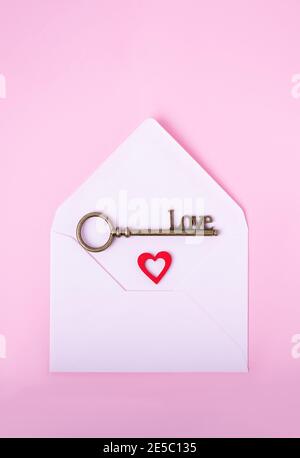 Love key and red heart in an envelope on a pink background, top view, copy space Stock Photo