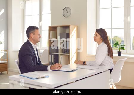 Businessman discussing project with woman manager or interviewing candidate for vacancy in office Stock Photo