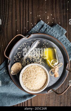 Sesame seeds in wooden bowl and scoop isolated on white background with ...