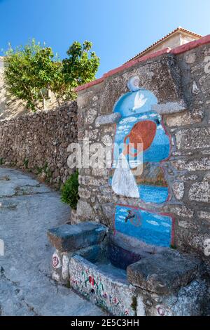 Painted wall on an old public fountain, in the mountainous village of Klio (or Kliu), in Lesvos island, Aegean Sea, Greece, Europe. Stock Photo