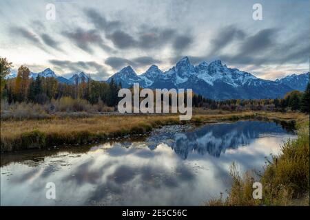 autumn evening shot of the snow covered teton mountains reflected in calm water at schwabachers landing of grand tetons national park, wyoming Stock Photo