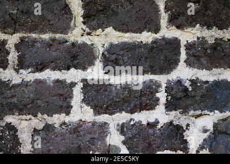 Old brickwork wall of dark bricks. Stock Photo