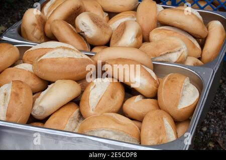 Many crusty bread rolls in a metal container for sale Stock Photo