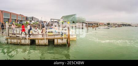 Panoramic view over busy Grand Canal, piers and main port with tourists disembark from a waterbus (vaporetto) in Venice, Italy Stock Photo