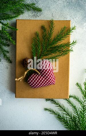 Rustic gift box with a pinecone and fir branch with a heart shape decoration Stock Photo