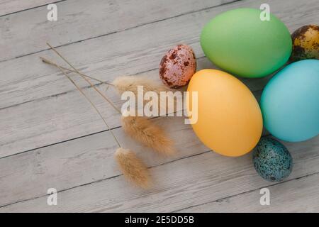 Many colorful painted Easter eggs on wooden background, top view. Stock Photo