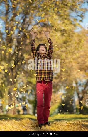 Boy throwing autumn leaves in the air, Bulgaria Stock Photo