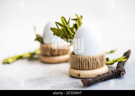 Two boiled eggs in egg cups with boxwood leaves Stock Photo