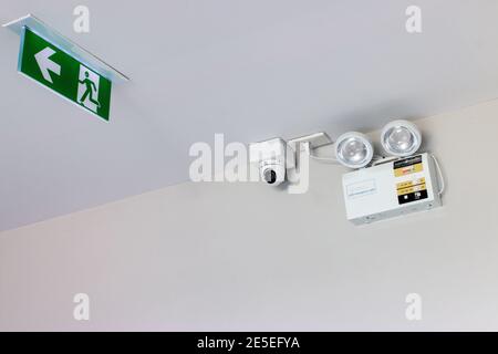 Emergency exit sign and security camera Stock Photo - Alamy
