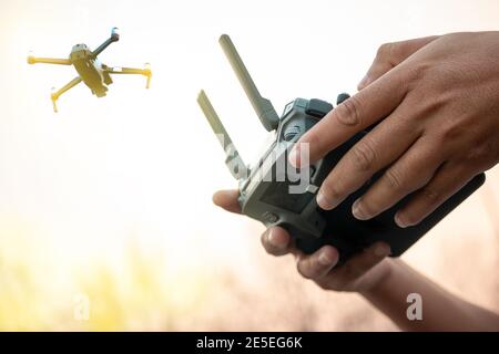 hands with remote controller of drone outside. Stock Photo