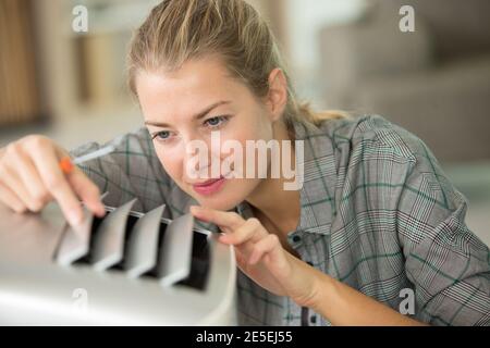 young woman checking air conditioning system Stock Photo