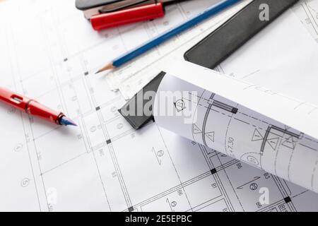 Rolls of architecture blueprints and house plans on the table and architect drawing tools. Stock Photo